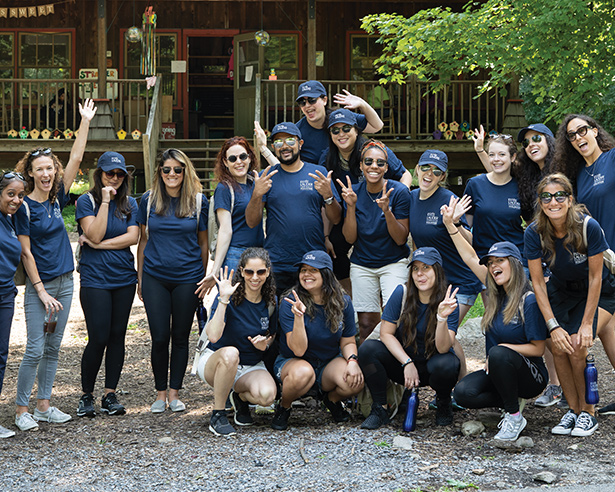 Group of people posing outside in navy blue shirts